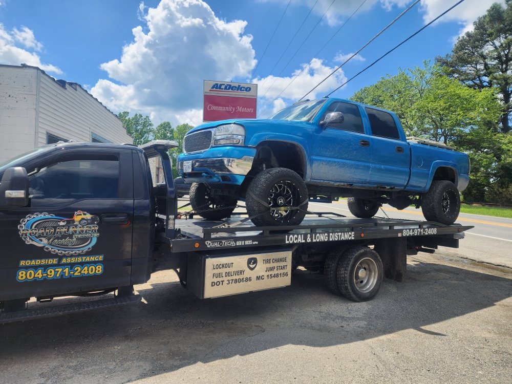 Lifted pickup truck loaded on a Roadrunner flatbed tow truck