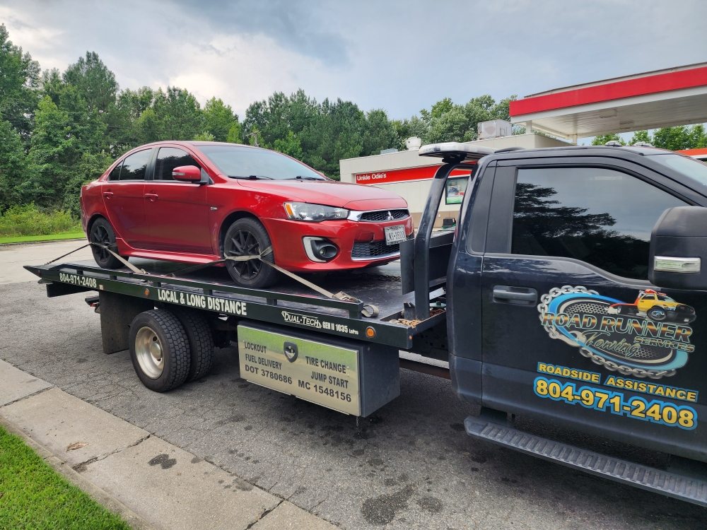 Roadrunner Towing Services flatbed tow truck loading a car in Richmond, Virginia