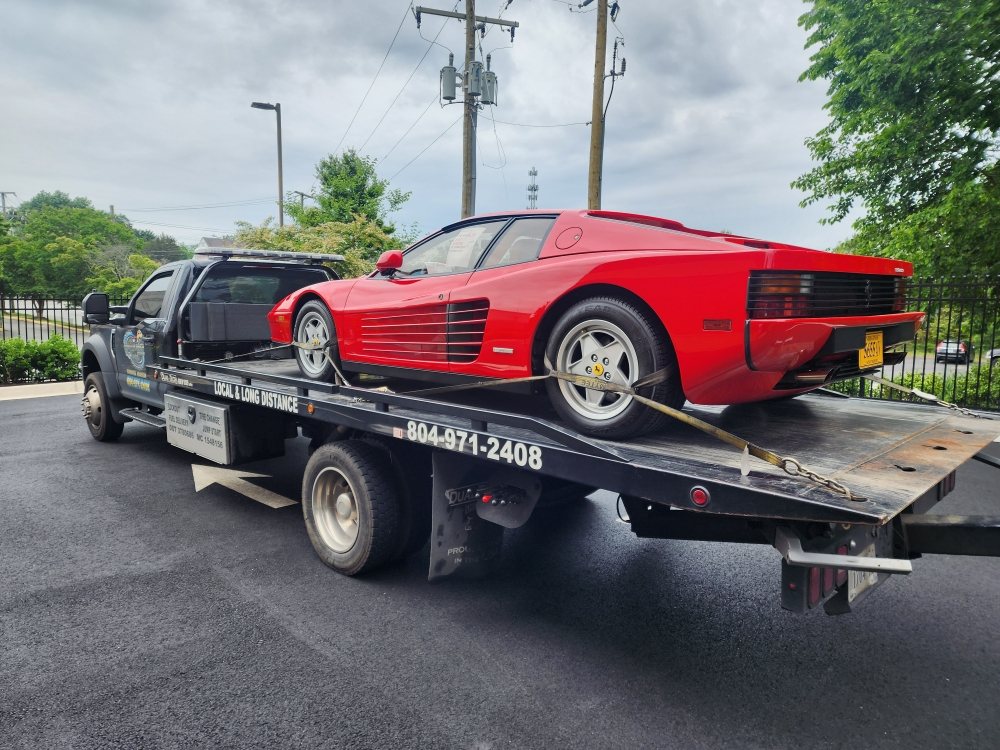 Roadrunner flatbed tow truck hauling a red sports car